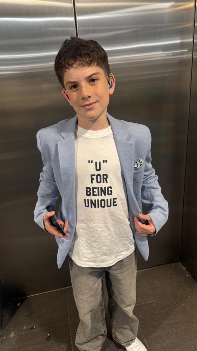 Eden today, in a blue blazer and a t-shirt reading U for being unique