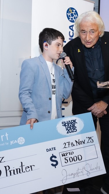 Eden accepting the Shark Tank 2025 cheque at a JCA Jumpstart event